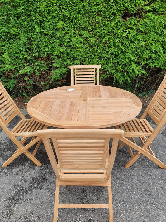 Wentworth round folding teak table and 4 folding chairs in front of a hedge
