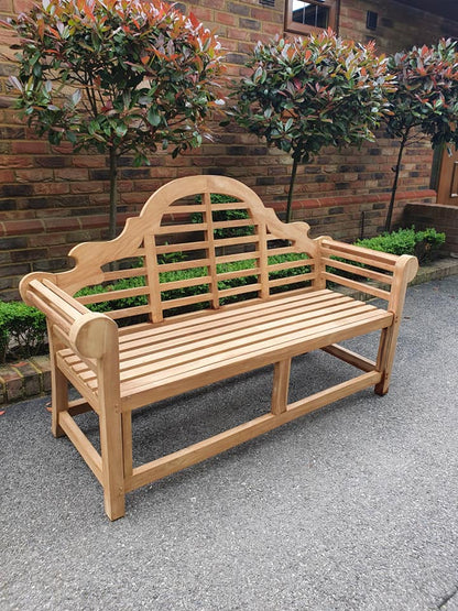 Lutyens teak bench from the side, showing the curved arched back and arms